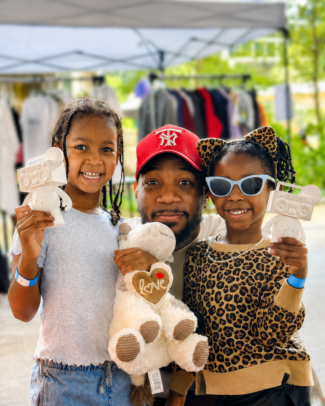Family posing with Boom Bear toys at a community market
