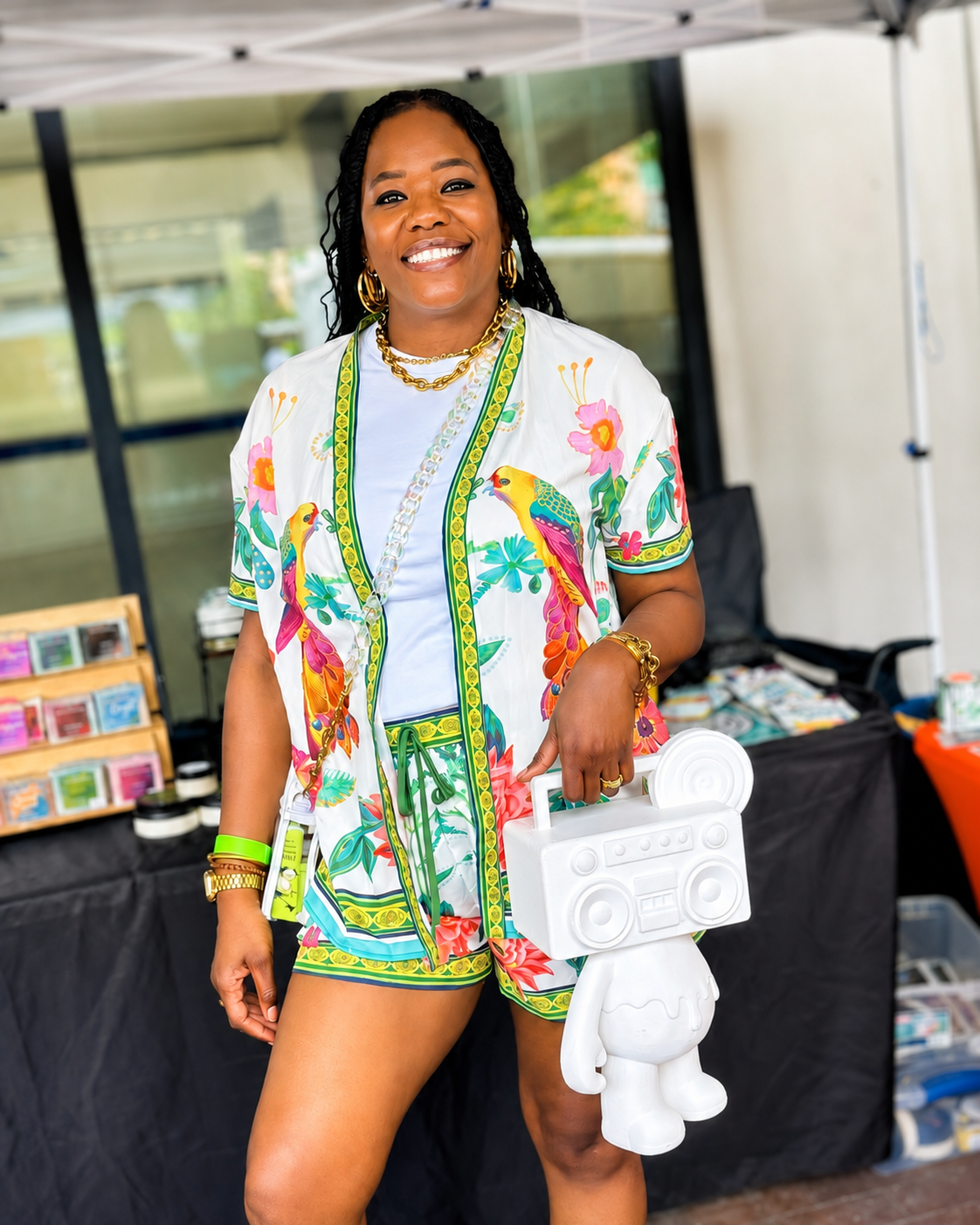 Customer smiling with a white Boom Bear figure at a pop-up market