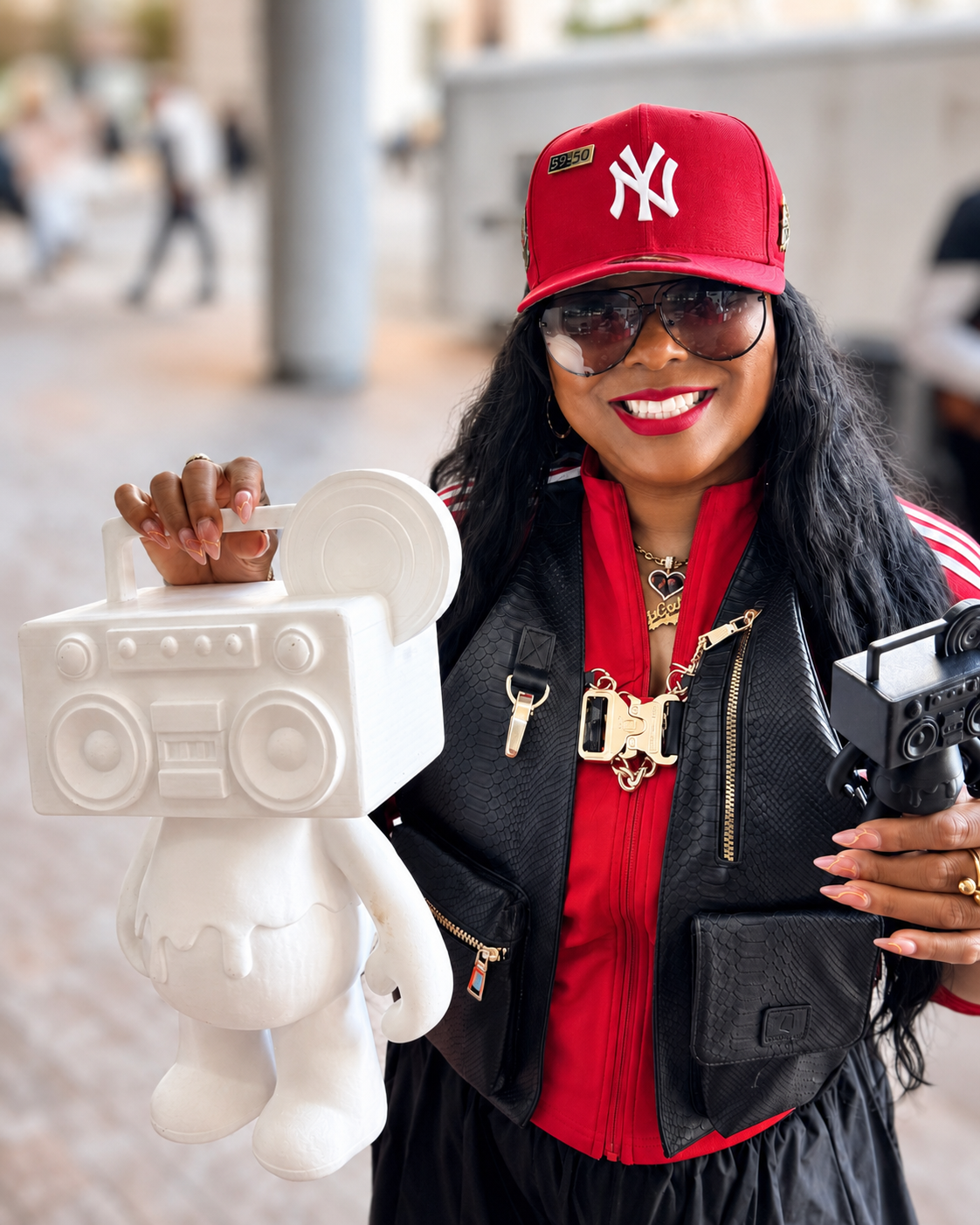 Customer in a red cap smiling and holding Boom Bear figures at an event