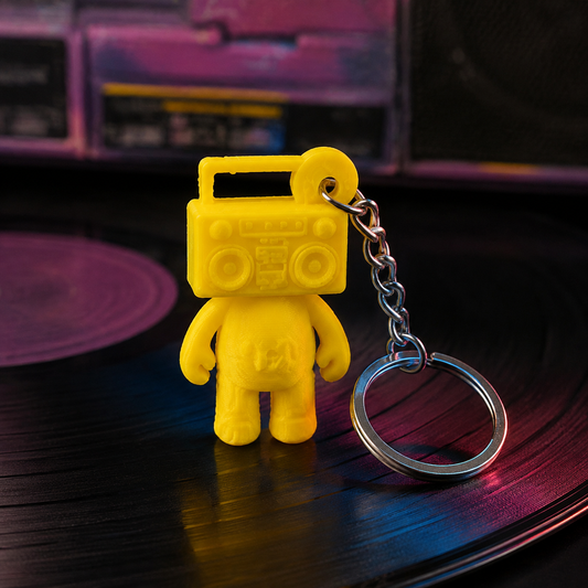 Mixtape Yellow Boom Bear Mixtape Head keychain standing on a black vinyl record with silver keyring