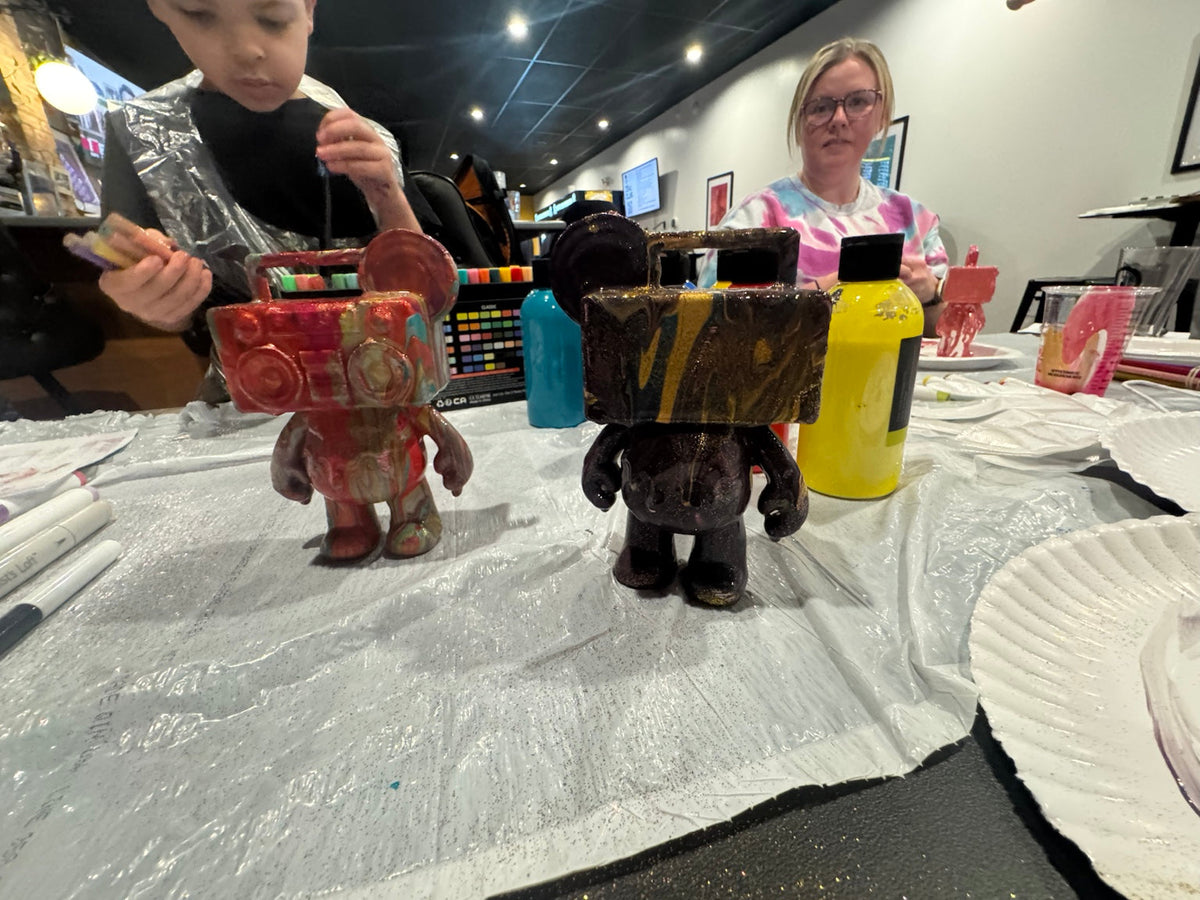 Two finished Drip Bears displayed on the table during a Boom Bear creative paint party